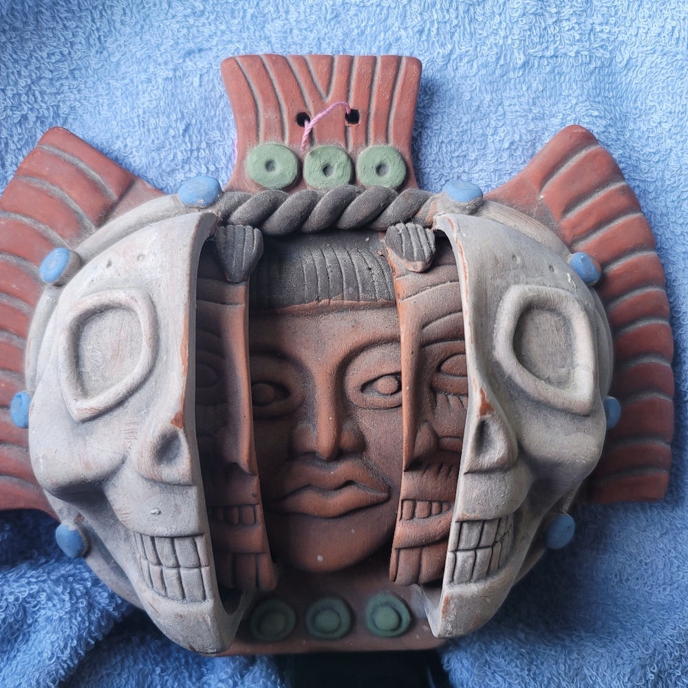 Three faces of man terra cotta relief